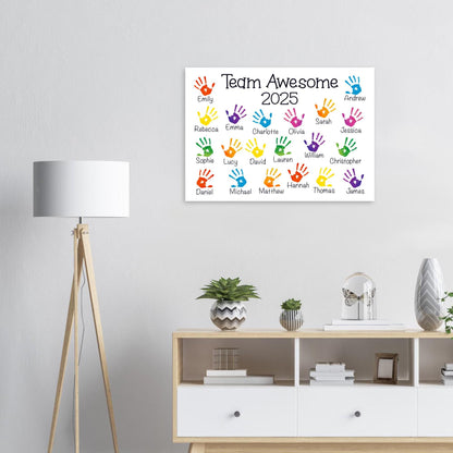 a colorful poster with handprints on it, hanging on a wall above a white cabinet with drawers.