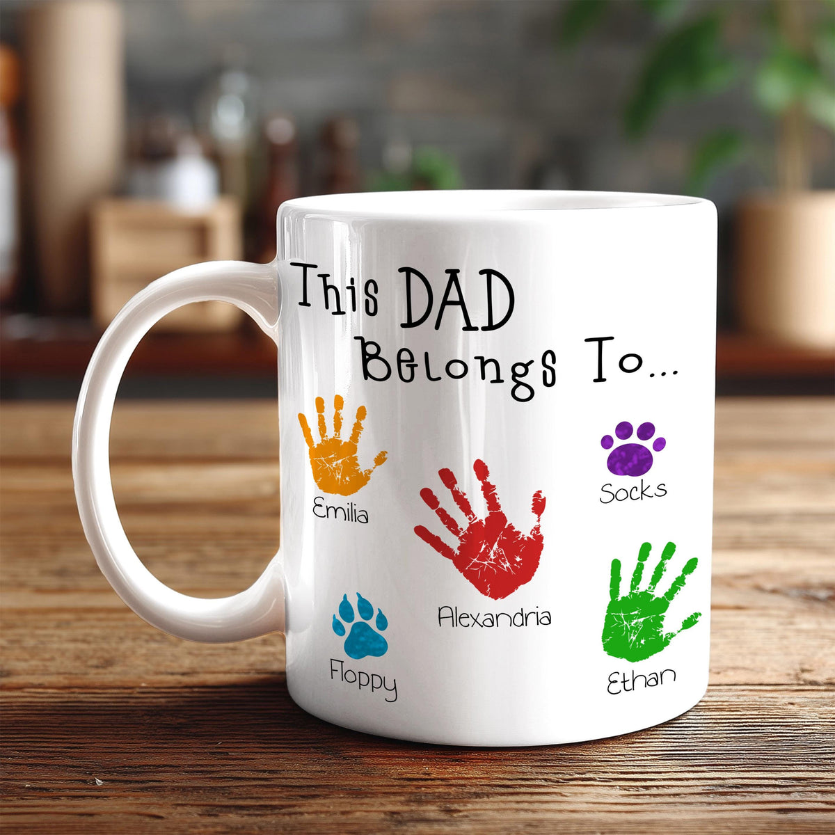 A white mug with a personalized message and handprints of the names of the children of the person who the mug is for.
