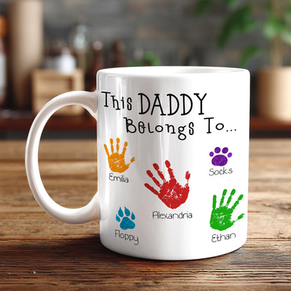A white mug with a personalized message and handprints of the names of the children of the person who made the mug.