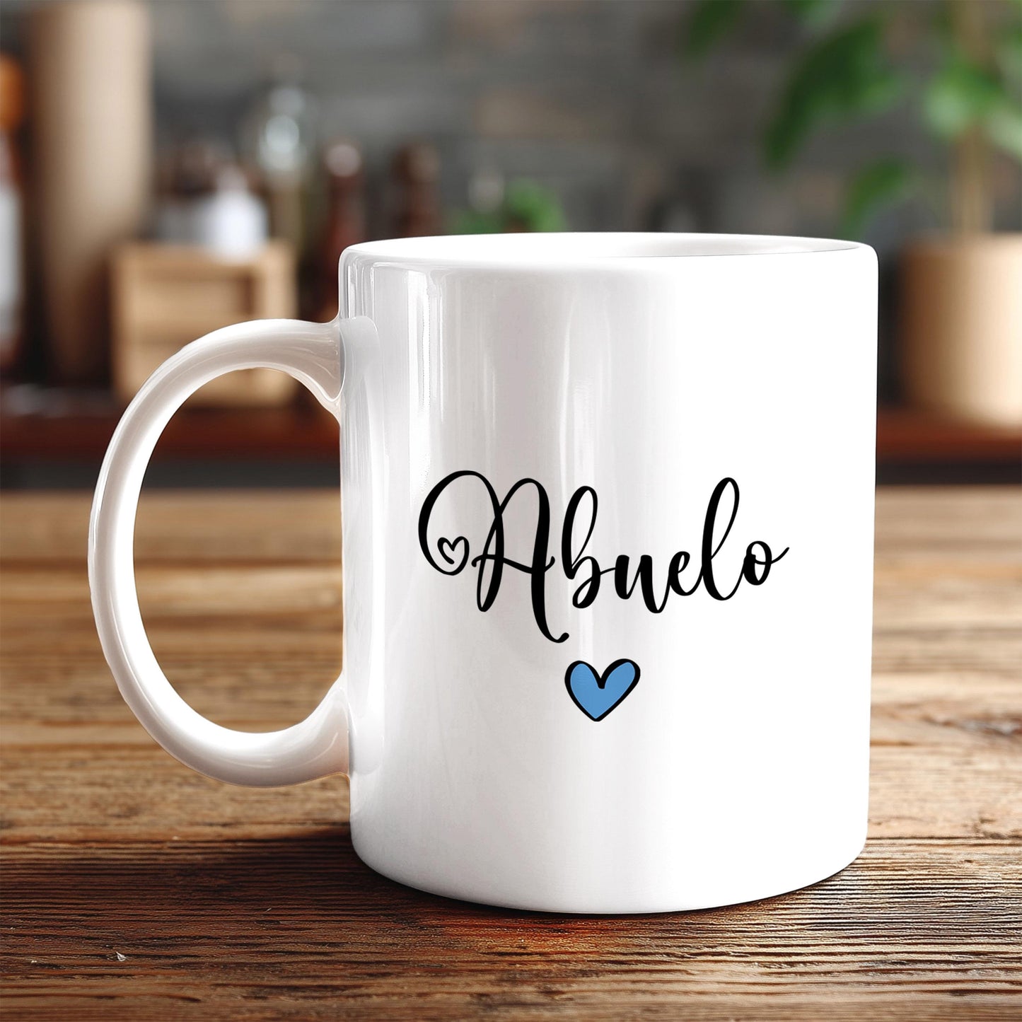 A white ceramic mug with the word "Abuelo" written on it, along with a blue heart symbol, sits on a wooden surface.