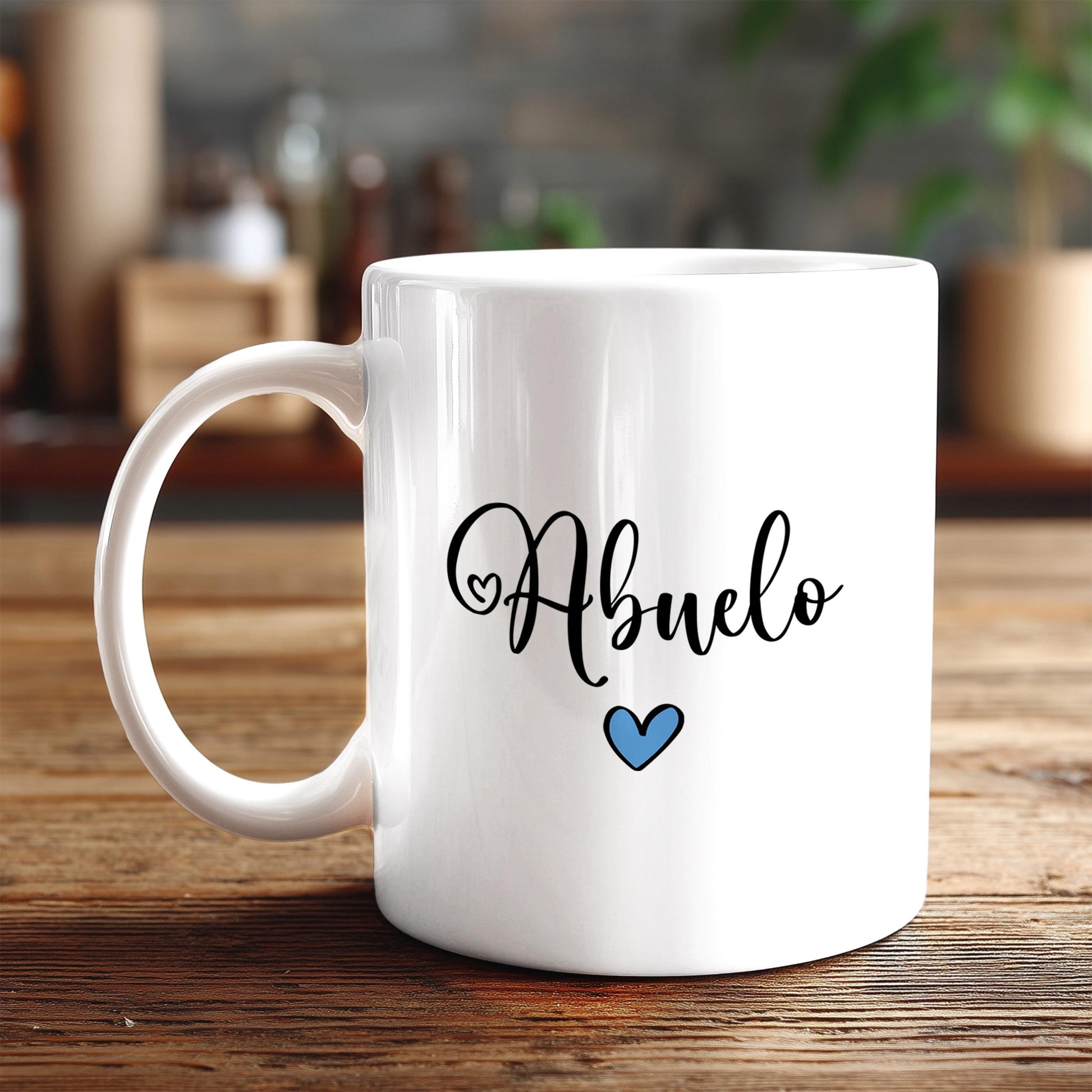 A white ceramic mug with the word "Abuelo" written on it, along with a blue heart symbol, sits on a wooden surface.