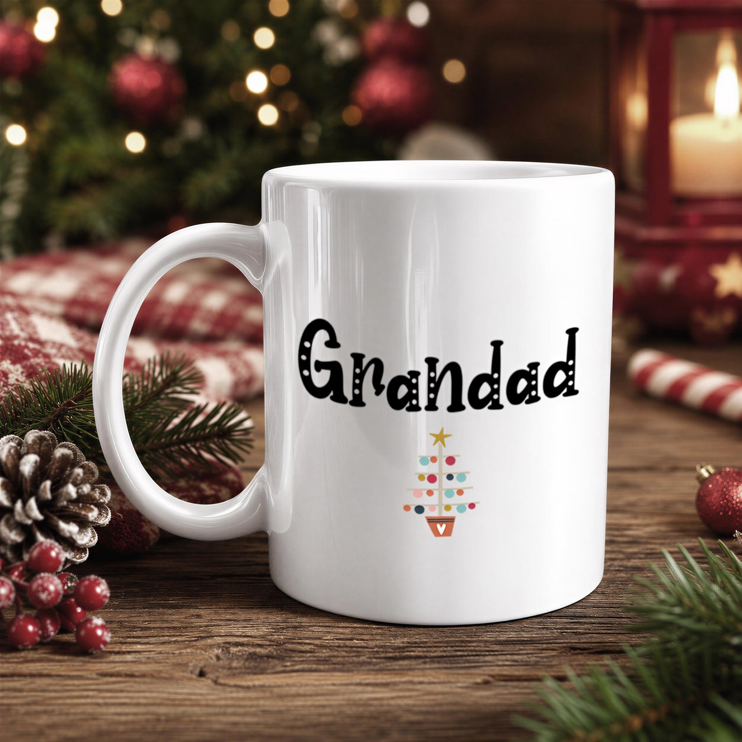 A white mug with the text "Grandad" printed on it, placed on a wooden surface with Christmas decorations in the background.