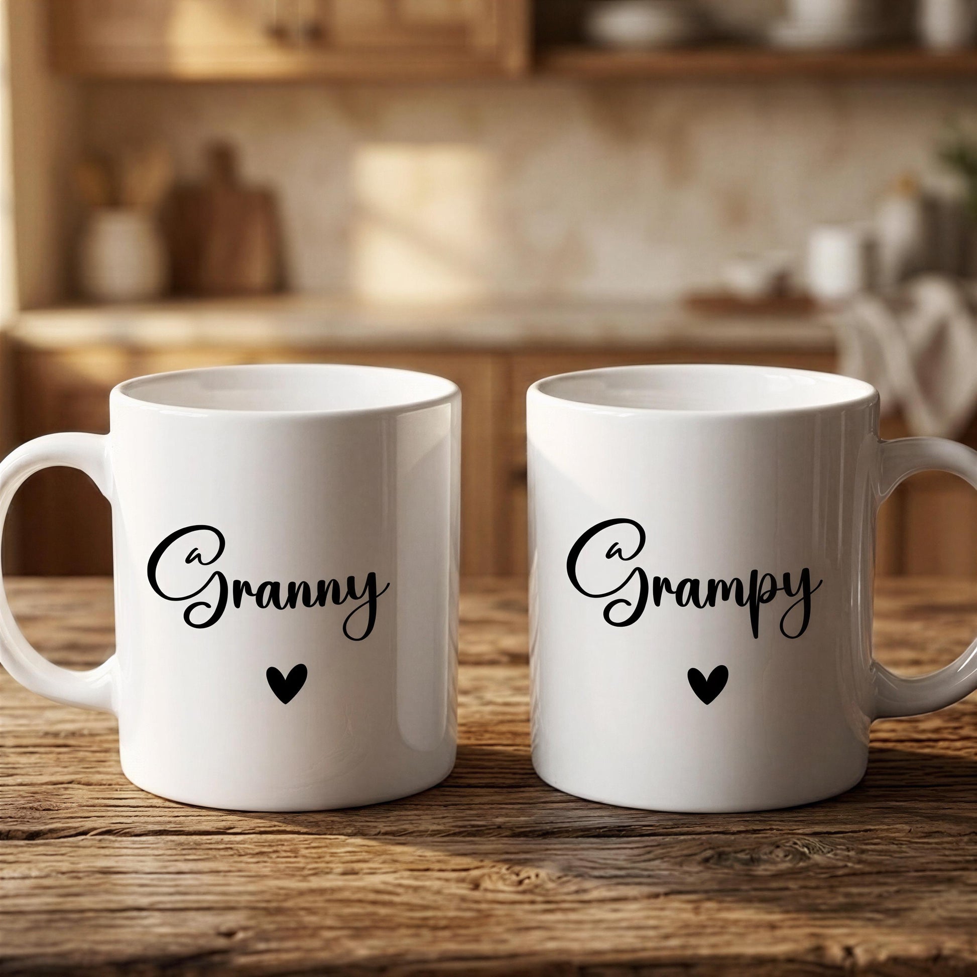 Two white coffee mugs with the text "A Granny" and a heart symbol printed on them, placed on a wooden surface.