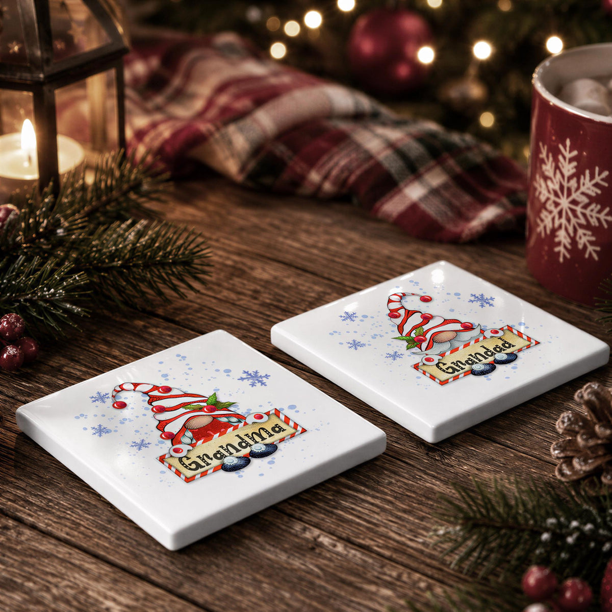 two white coasters with a Christmas-themed design, including a gnome and the word "Grandma", placed on a wooden surface.