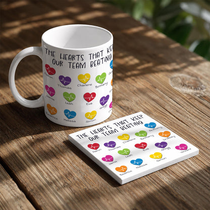 A white mug with a colorful design featuring heart shapes and text, and a coaster with heart shapes and text.