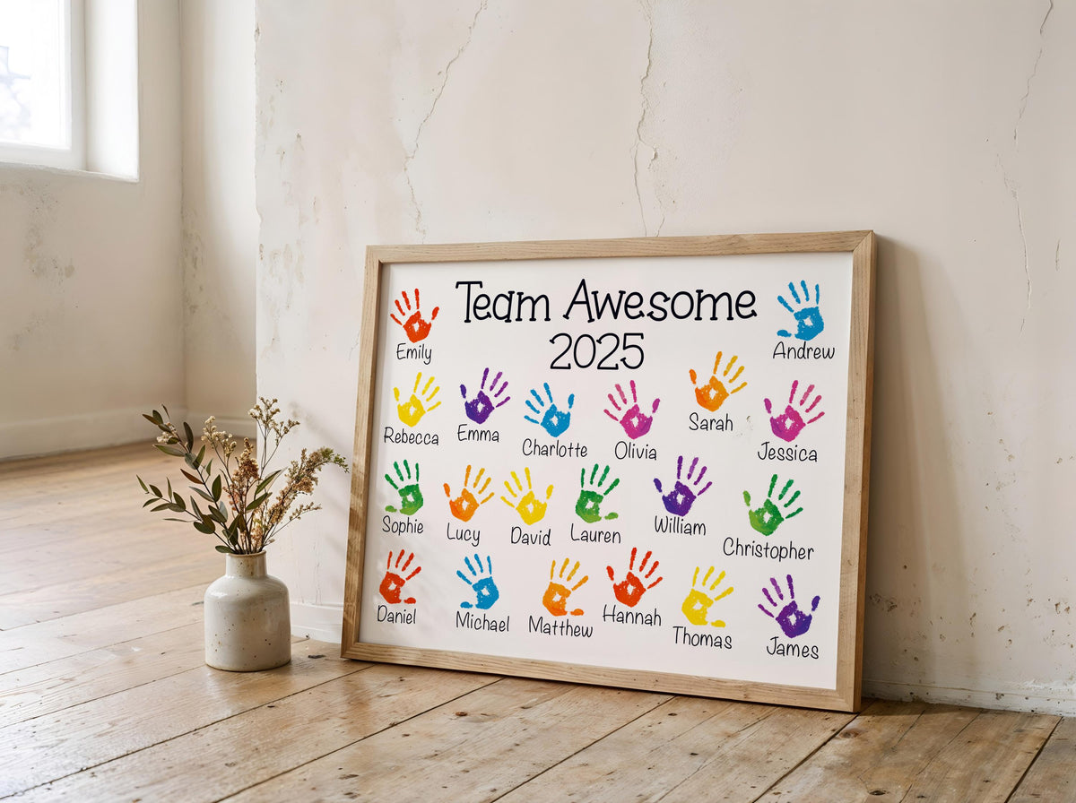 A framed poster titled "Team Awesome" with handprints of various people's names on it, placed on a wooden floor next to a vase with flowers.