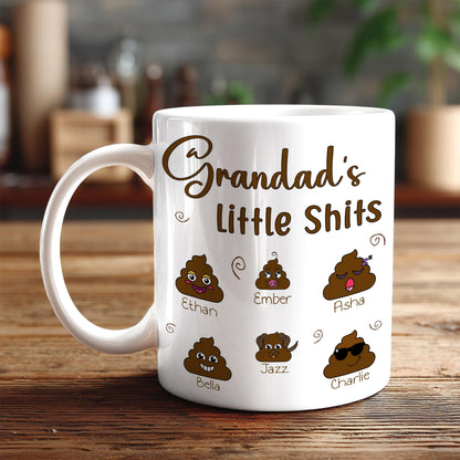 A white mug with a humorous design featuring six cartoon poop faces, each with a different name, along with the text "Grandad's little shit".